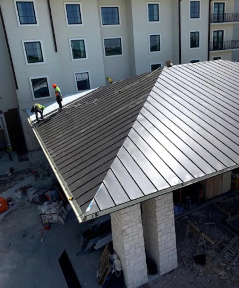 Crew installing standing seam metal roof panels on a commercial project in Dry Run